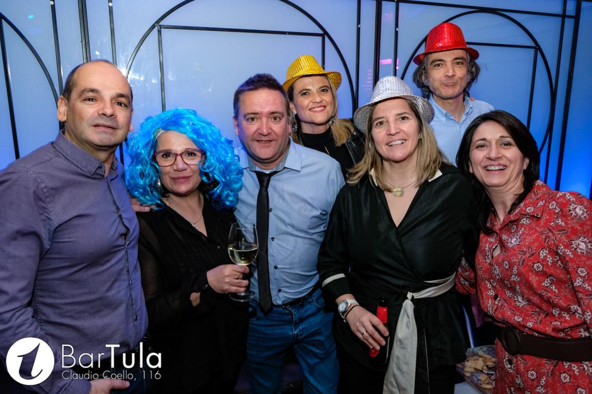 Grupos de personas ataviados con pelucas y gorros en una fiesta de empresa en Tula